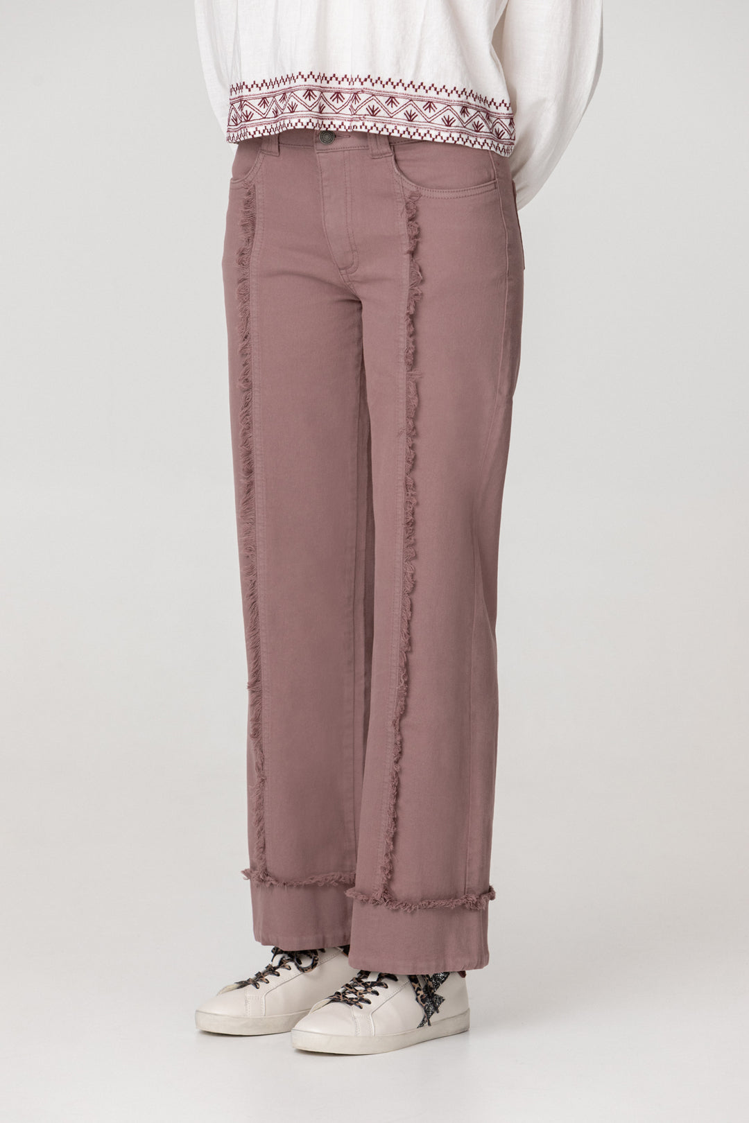 Calças de ganga com costuras desfiadas e bainha dobrada.