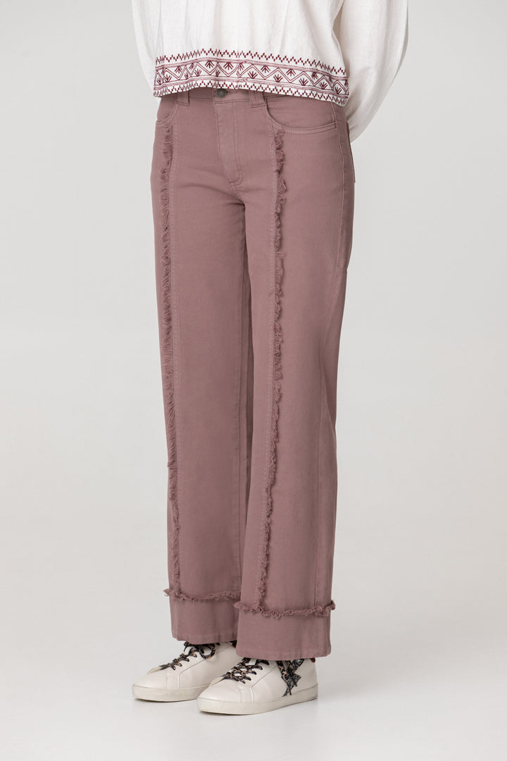 Calças de ganga com costuras desfiadas e bainha dobrada.