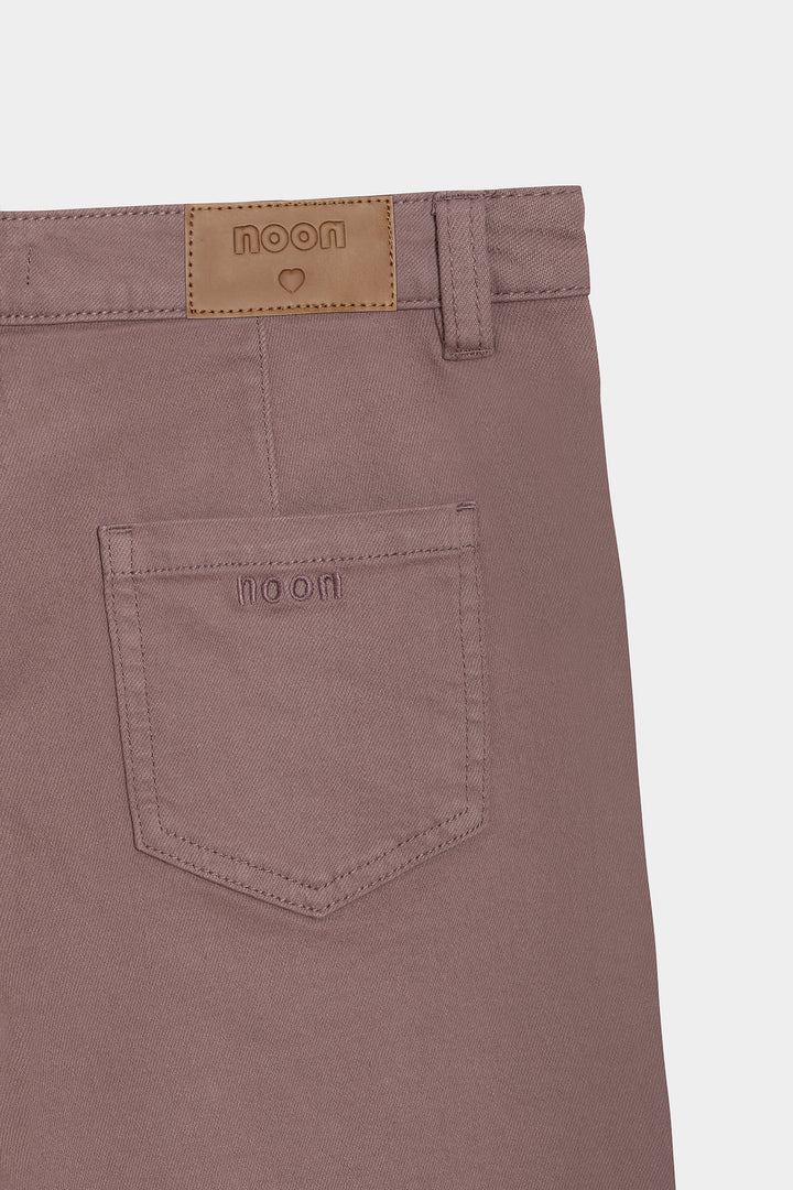 Calças de ganga com costuras desfiadas e bainha dobrada.