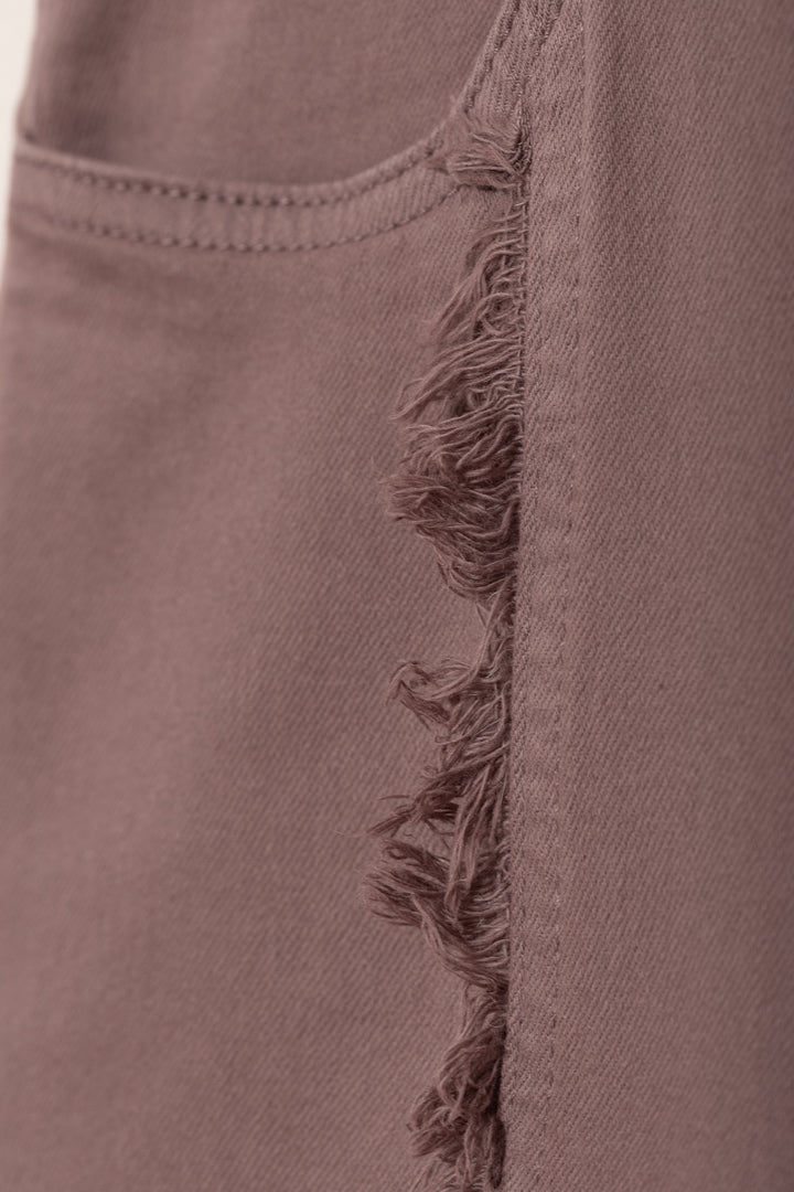 Calças de ganga com costuras desfiadas e bainha dobrada.